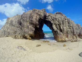 Rocks on beach against blue sky