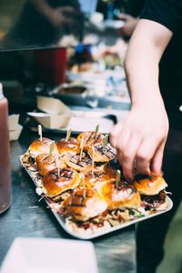 Cropped hand of vendor preparing food at market stall