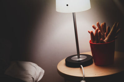 Close-up of hand holding candles on table at home