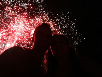 People enjoying illuminated firework display at night