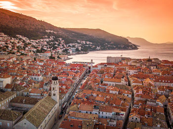 High angle view of townscape by sea against sky