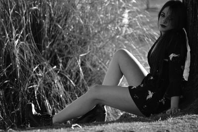 Portrait of young woman sitting on field