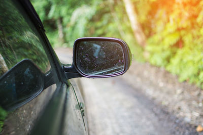 Wet side-view mirror of car during rainy season