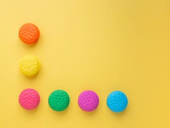 Close-up of multi colored candies against yellow background