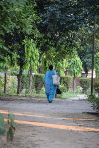 Rear view of a man walking on road