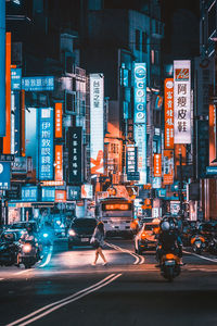 People on road amidst buildings in city