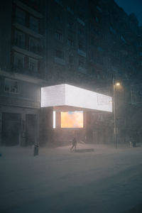 Back view of anonymous man in outerwear walking on roadway in snowy winter in madrid spain