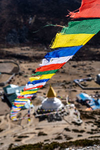 Close-up of multi colored flags on beach