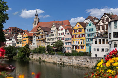 Buildings by river in town against sky