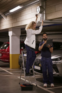 Man and woman checking air duct