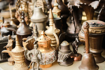 Close-up of containers and figurines for sale on table in store