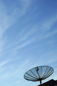 Low angle view of communications tower against blue sky