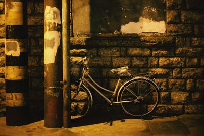 Bicycle parked against brick wall