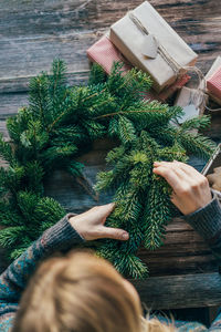 Woman making natural fir festive advent christmas wreath. new year celebration.