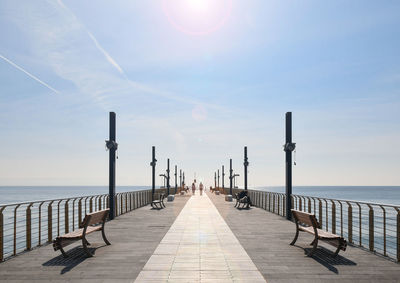 Pier over sea against sky during sunset