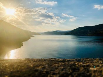 Scenic view of sea against bright sun