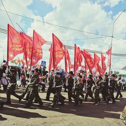 Group of people on road against sky in city