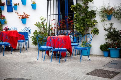 Empty chairs and tables in cafe against buildings in city