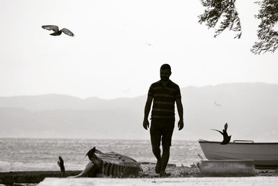 Full length of man standing by sea against sky