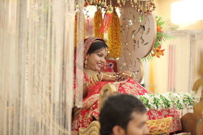 Smiling bride sitting in cart during wedding ceremony