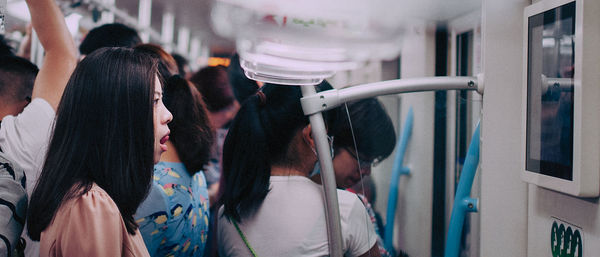 Rear view of people walking on tiled floor