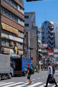 People on city street against buildings