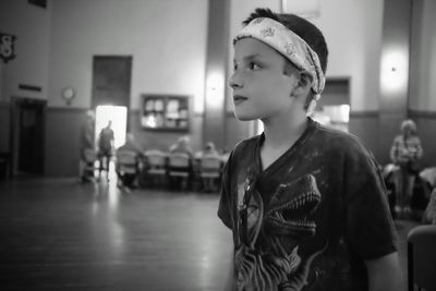 Boy looking away while standing on floor