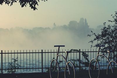 Bicycle by railing against sky