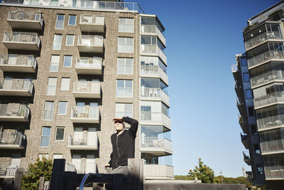 Young man in front of blocks of flats