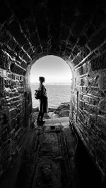 Rear view of man standing in tunnel