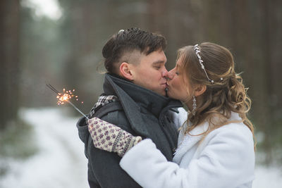 Happy couple with sparklers during winter