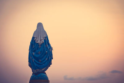 Low angle view of silhouette sculpture against clear sky during sunset