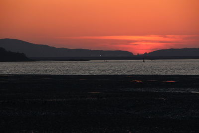 Scenic view of sea against orange sky