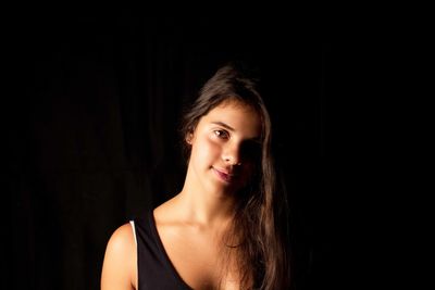 Portrait of a beautiful young woman over black background