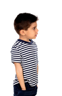 Boy looking away while standing against white background