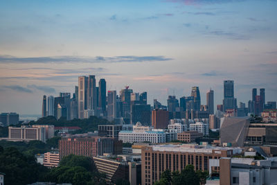 Modern cityscape against sky during sunset