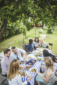 High angle view of friends and family enjoying at dining table in garden party