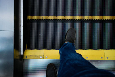 Low section of person standing on yellow car