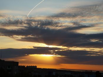 Silhouette buildings against sky during sunset