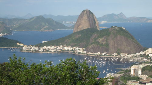 Harbor in sea by sugarloaf mountain against sky