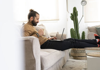 Rear view of woman sitting on sofa at home