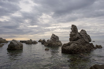 Rocks in sea against sky