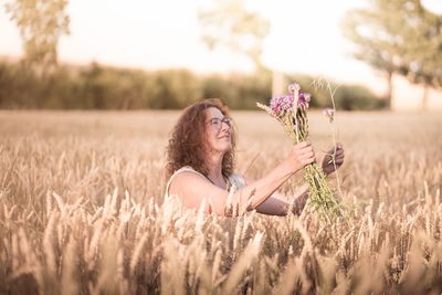 Young woman with flowers on field