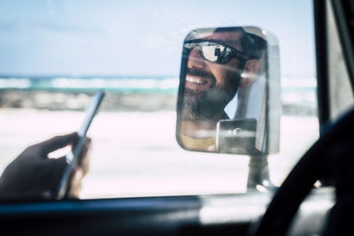 Portrait of man using smart phone in car