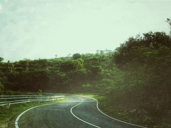 Road amidst trees against sky