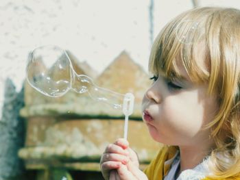 Close-up of young woman holding bubbles