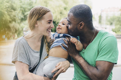 Smiling parents embracing son at park