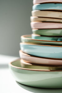 A large stack of ceramic cups in pastel colors.