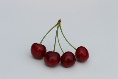 Close-up of cherries over white background
