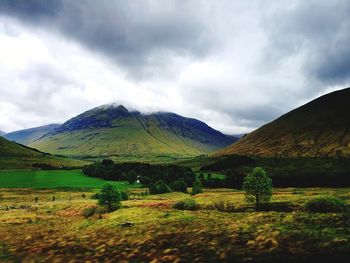 Scenic view of field and mountains against sky